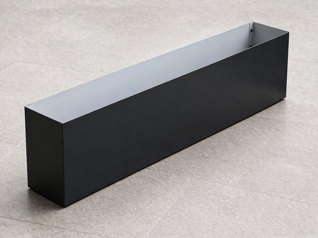 Black rectangular planter box on a light gray floor